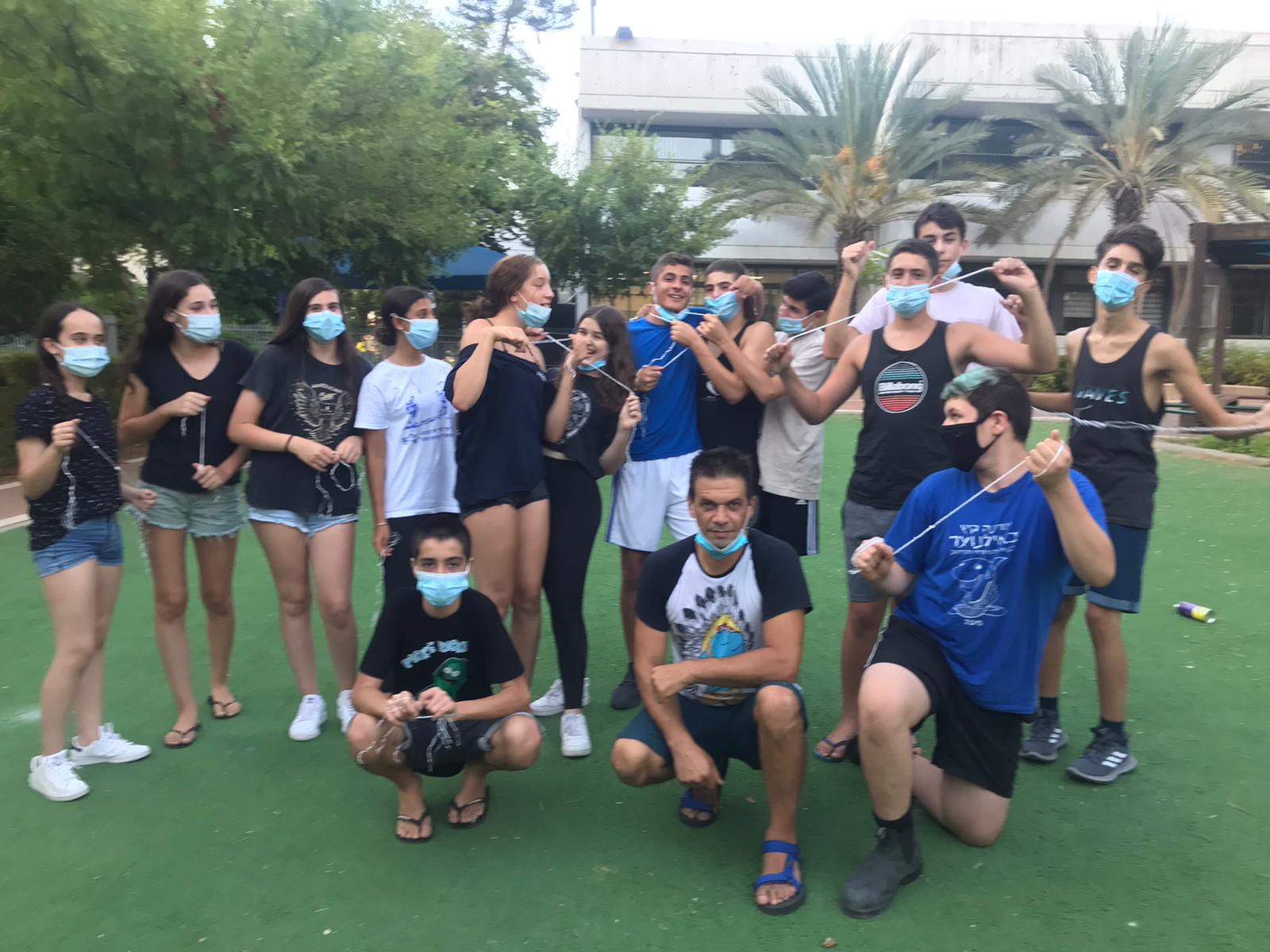 בני נוער עם מסכות בגינה ציבורית