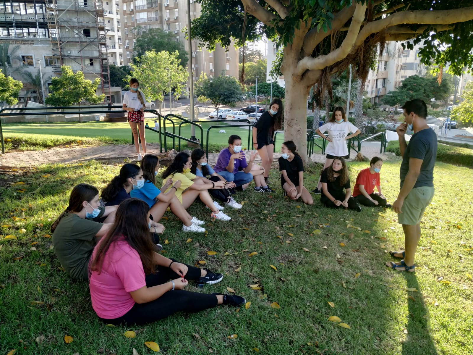 בני נוער עם מסכות בגינה ציבורית