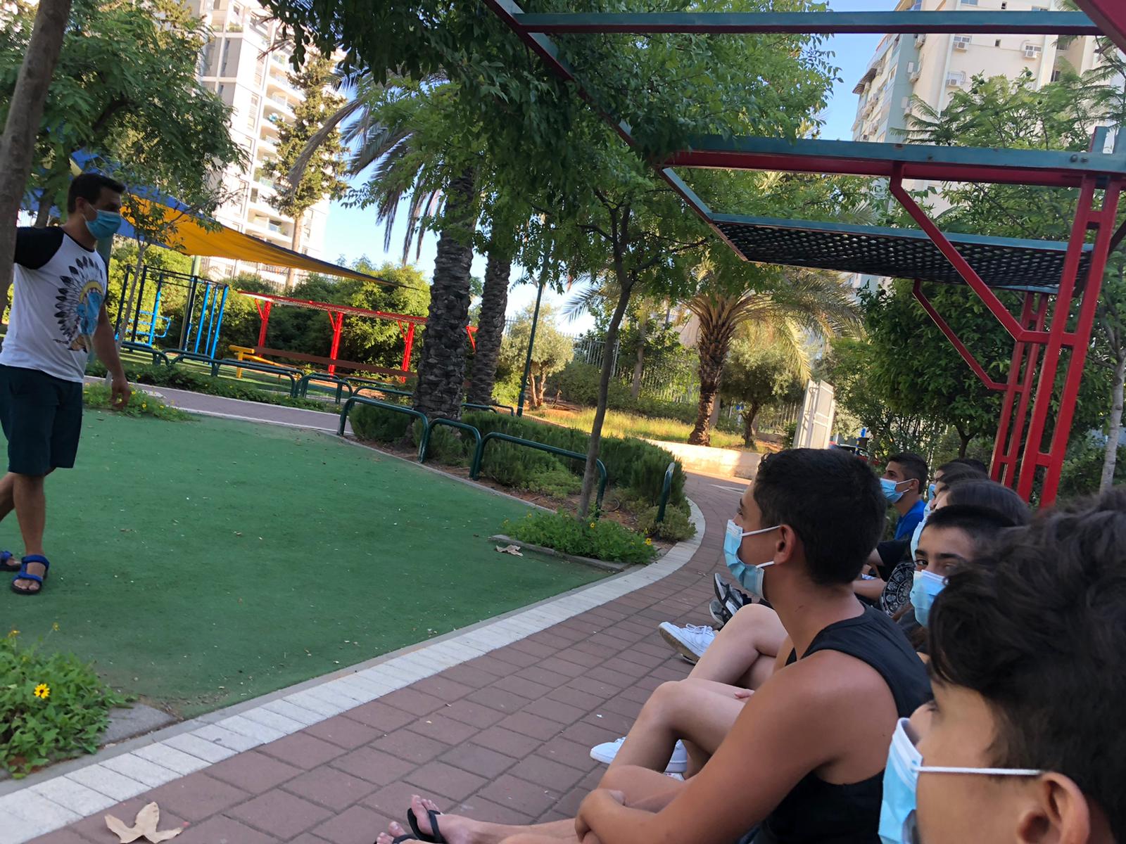 בני נוער עם מסכות בגינה ציבורית