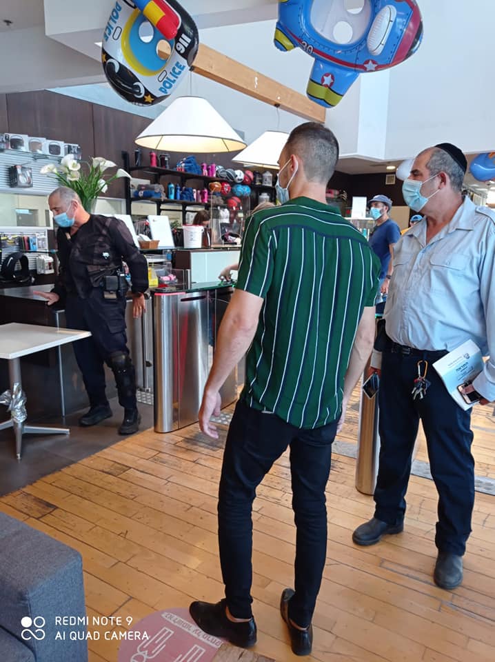 פקחים עוטי מסכות באכיפה בתוך חנות