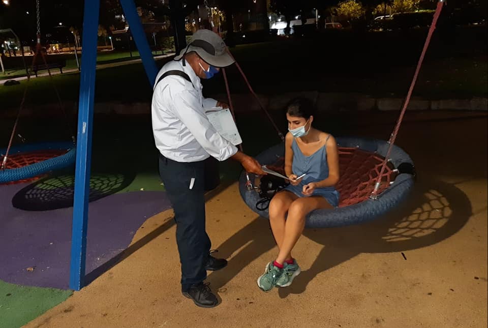 פקח נותן דוח לתושבת בגן משחקים