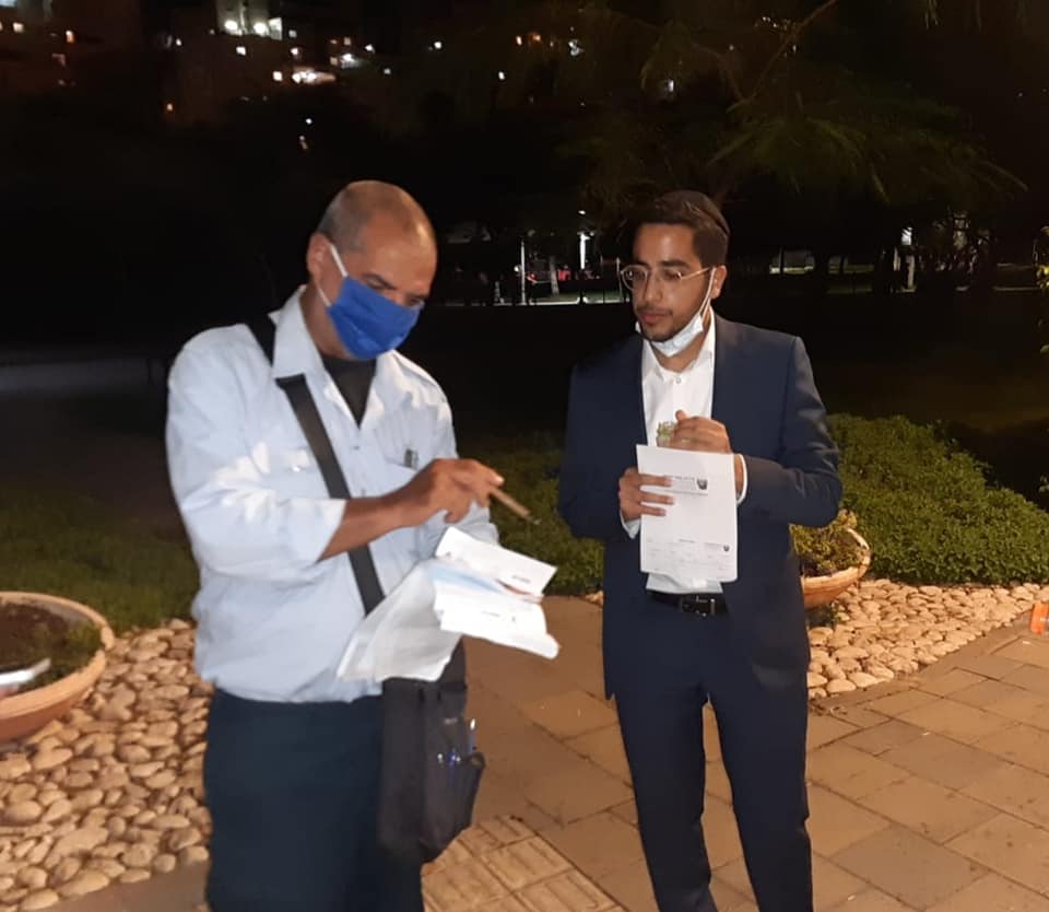 פקח נותן דוח לתושב בגן משחקים