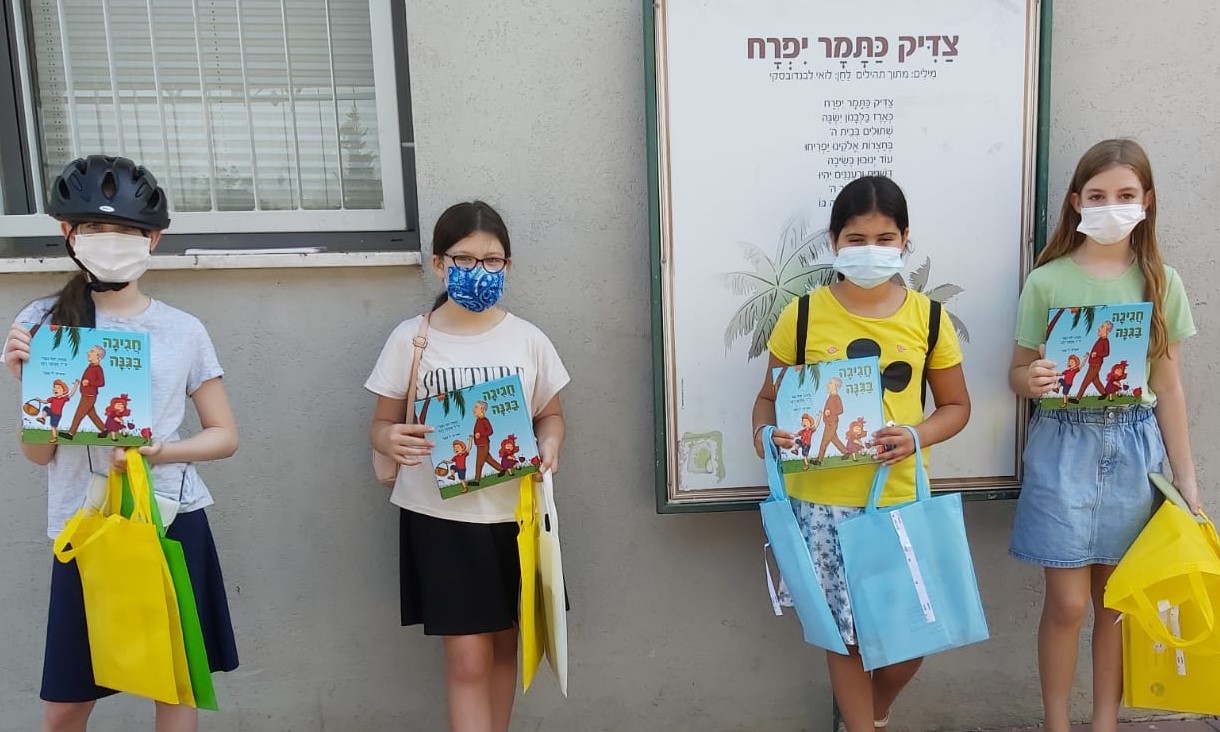 תלמידי כיתות ג בחלוקת הספרים לביתם של ילדי כיתות א