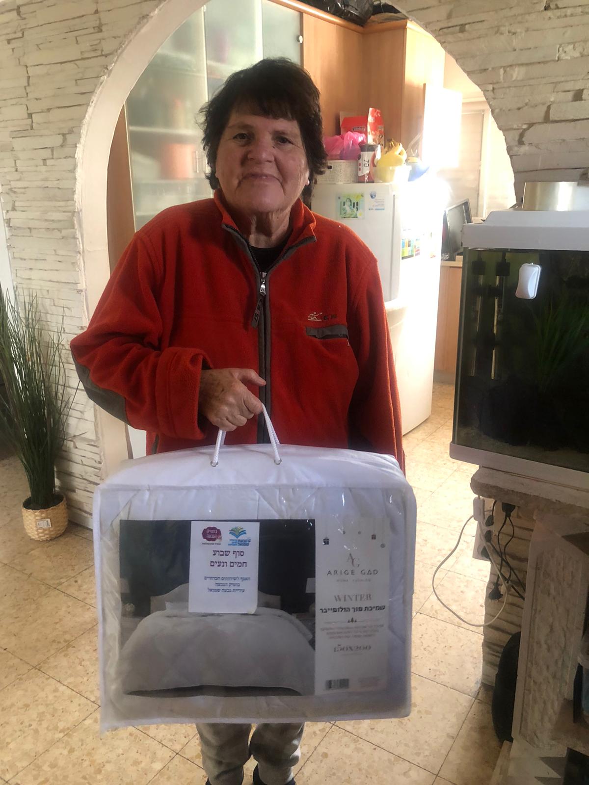 גמלאית אוחזת בידה שי שמיכה