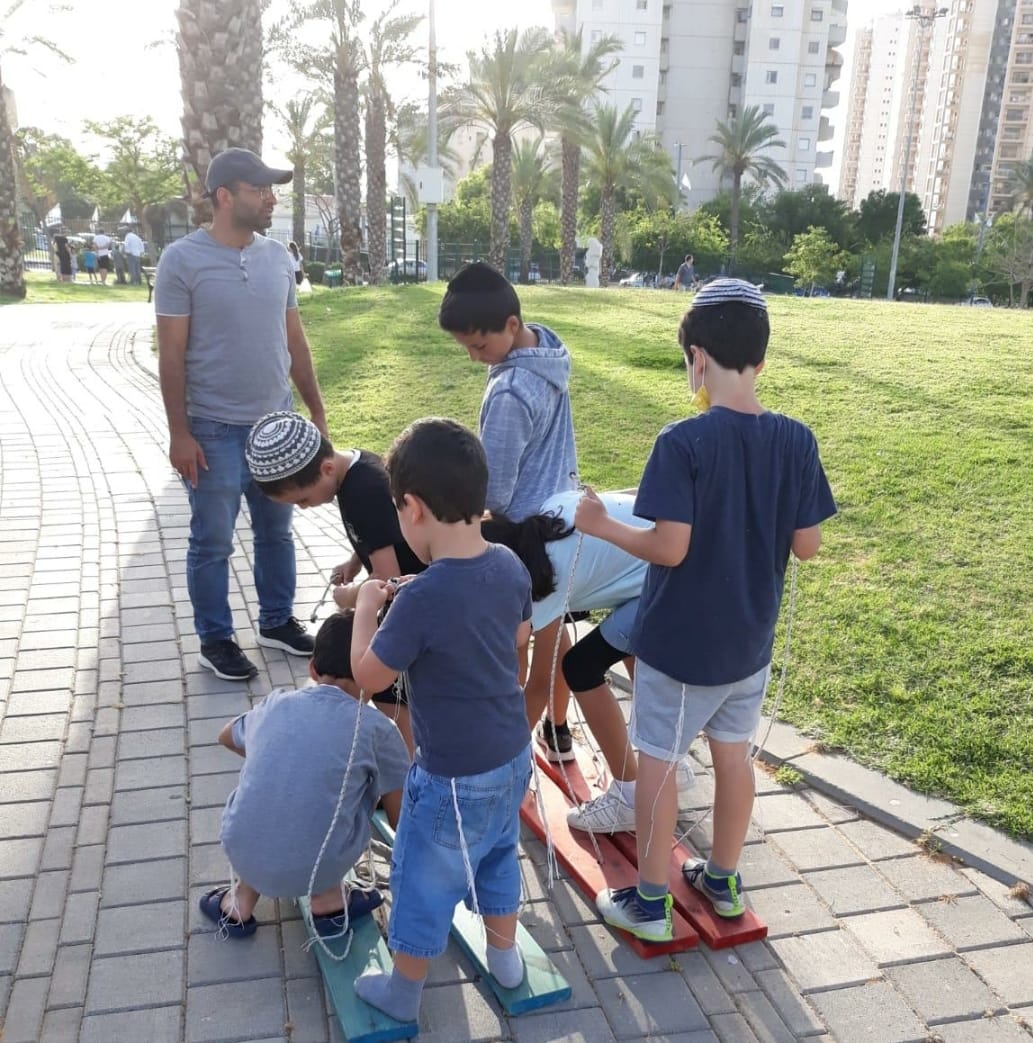 נערים ומדריך משחקים בגינה ציבורית